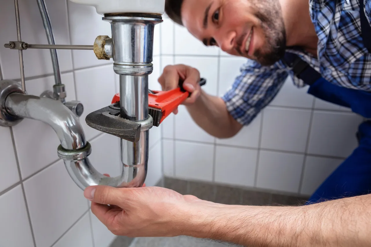 Plombier raccordant un chauffe-eau lors d'une intervention à Ris-Orangis (91130)